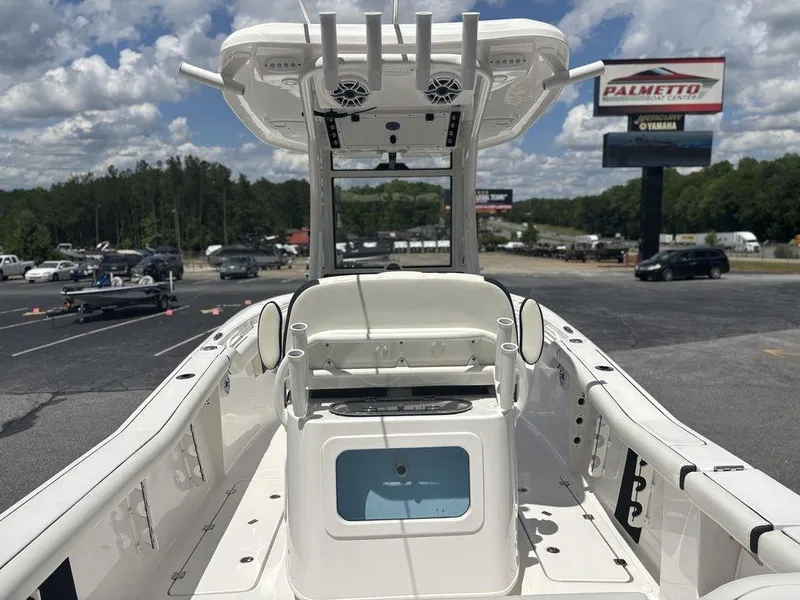 Slide: The Image of 2024 Tidewater 256 CC Adventure boat interior with seating and storage, parked outdoors. - 14