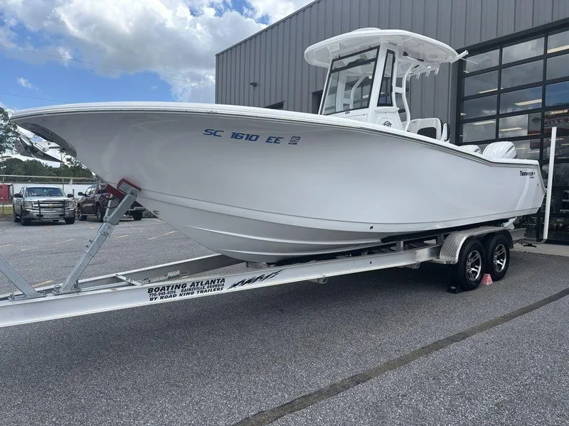 Slide: The Image of 2024 Tidewater 256 CC Adventure boat on trailer, parked outdoors. - 16