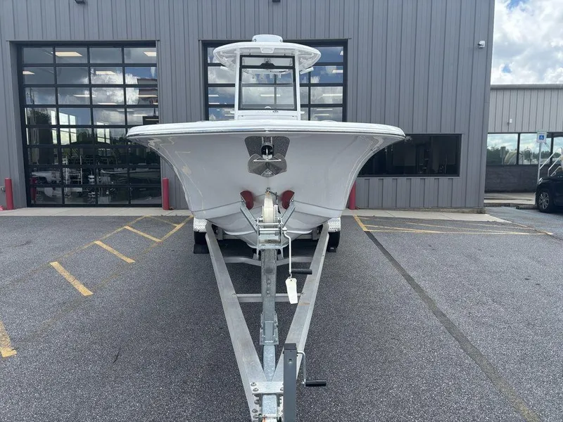 Slide: The Image of 2024 Tidewater 256 CC Adventure boat on trailer, parked outside a building. - 17