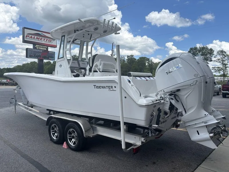 Slide: The Image of 2024 Tidewater 256 CC Adventure boat on trailer, parked outdoors under a cloudy sky. - 19