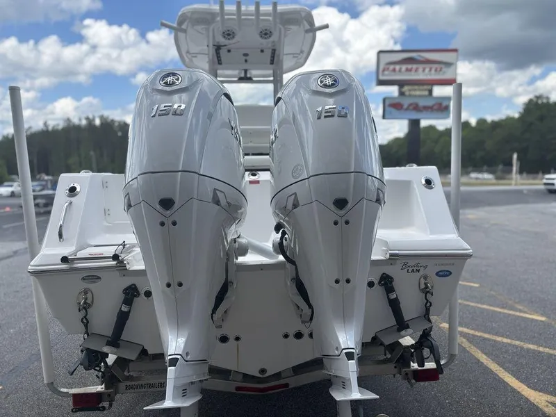 Slide: The Image of 2024 Tidewater 256 CC Adventure boat with dual 150 horsepower engines, parked outdoors. - 21