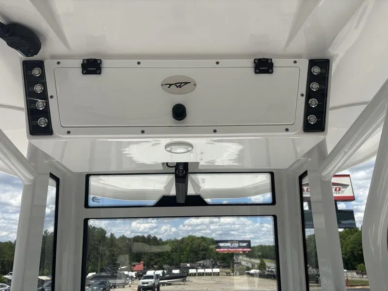 Slide: The Image of 2024 Tidewater 256 CC Adventure boat console with overhead storage and controls. - 23