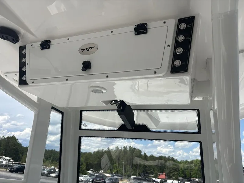 Slide: The Image of 2024 Tidewater 256 CC Adventure boat console with control panel and storage compartment. - 24