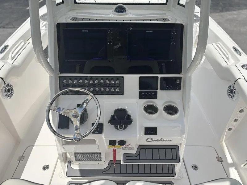 Slide: The Image of 2024 Tidewater 256 CC Adventure boat console with steering wheel, controls, and dual displays. - 9