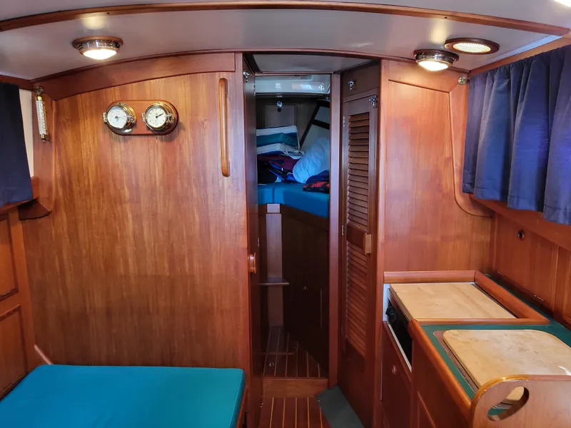 Slide: The Image of Interior of a 1978 Fisher 25 boat with wood paneling and blue cushions. - 13