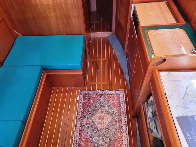 Slide: The Image of Interior of a 1978 Fisher 25 boat with wood flooring and blue cushions. - 15