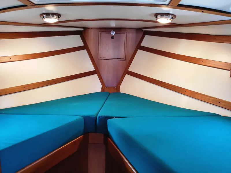 Slide: The Image of 1978 Fisher 25 boat interior with blue cushions and wooden accents. - 20