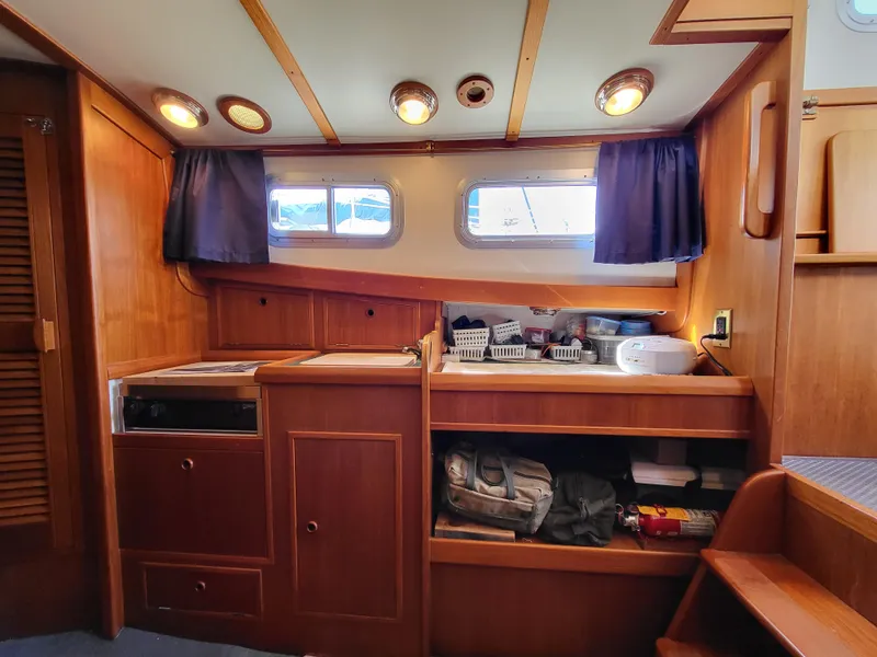 Slide: The Image of 1978 Fisher 25 boat interior with wooden cabinetry and storage shelves. - 22