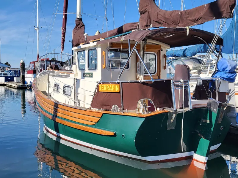 Slide: The Image of 1978 Fisher 25 sailboat with green hull and brown sails docked in marina. - 3
