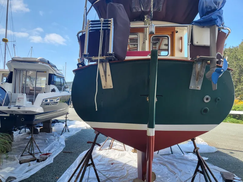 Slide: The Image of 1978 Fisher 25 boat on stands, green hull, marina background, clear sky. - 37