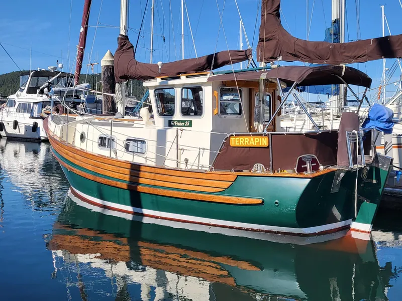Slide: The Image of 1978 Fisher 25 sailboat docked in marina, featuring green hull and wooden accents. - 4