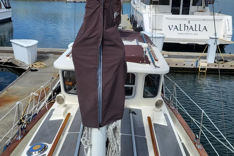 Slide: The Image of 1978 Fisher 25 sailboat docked, featuring a covered mast and nearby yacht "Valhalla." - 5