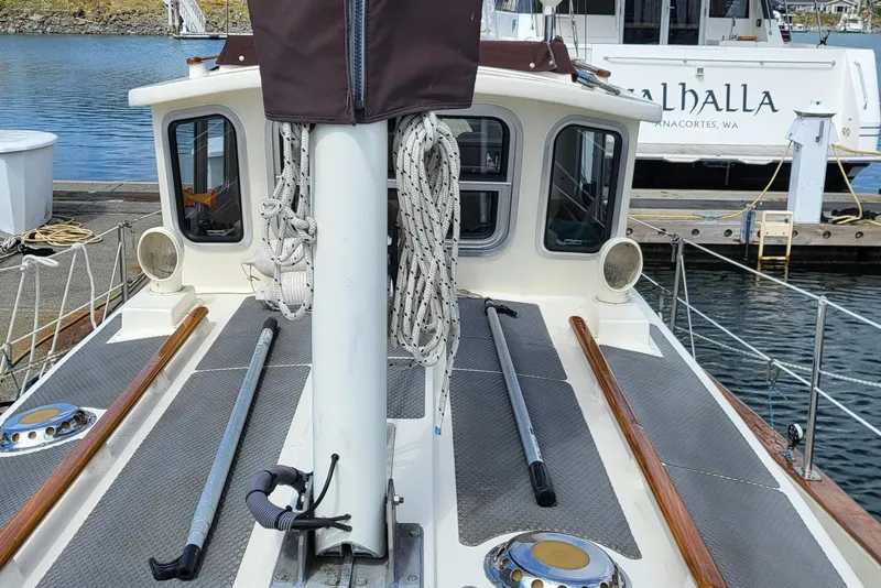 Slide: The Image of 1978 Fisher 25 sailboat deck with mast and ropes, docked at a marina. - 6