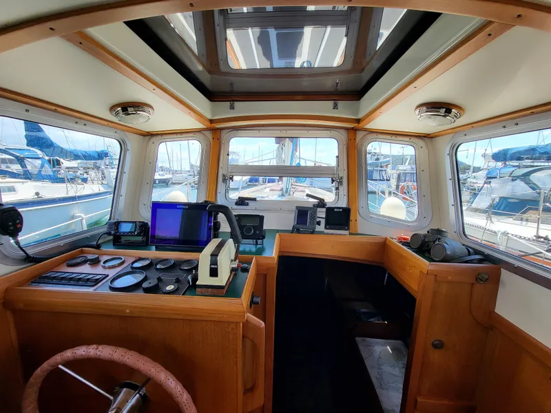 Slide: The Image of 1978 Fisher 25 boat interior with navigation equipment and wooden helm. - 7
