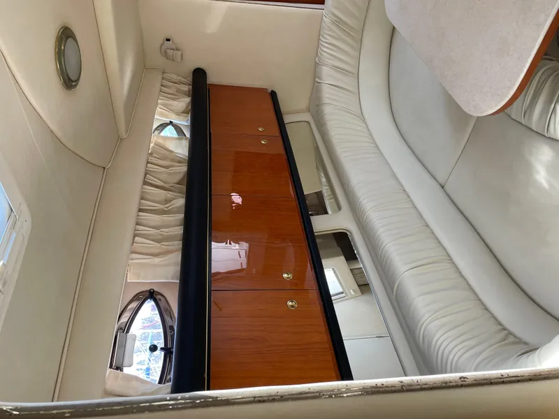 Slide: The Image of Interior of 2001 Sea Ray 340 Sundancer with white leather seating and wooden cabinetry. - 17