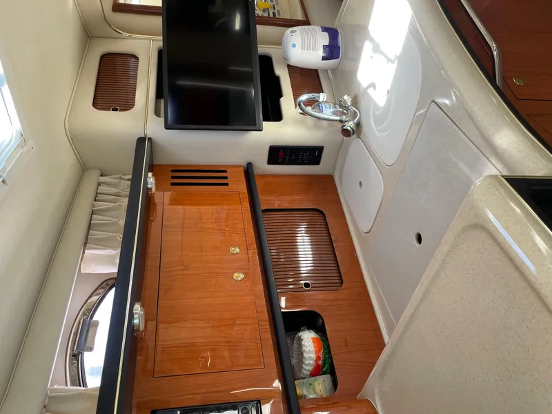 Slide: The Image of 2001 Sea Ray 340 Sundancer interior with wooden cabinetry and modern amenities. - 19