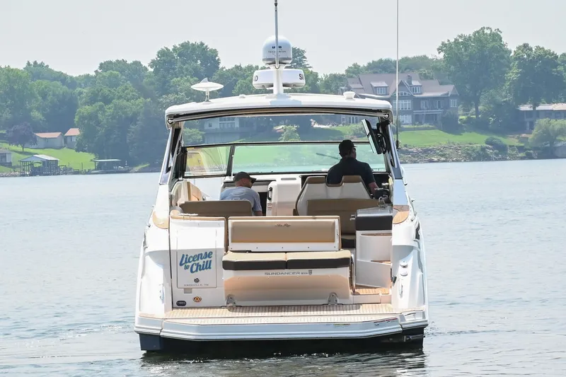Slide: The Image of 2020 Sea Ray Sundancer 320 Coupe cruising on a serene lake with lush greenery. - 1
