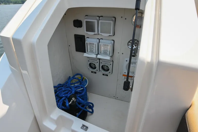 Slide: The Image of 2020 Sea Ray Sundancer 320 Coupe storage compartment with blue rope and electrical panels. - 11