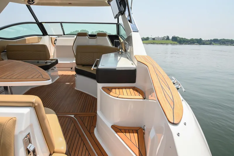 Slide: The Image of 2020 Sea Ray Sundancer 320 Coupe interior with luxurious seating and wood accents on a calm lake. - 13