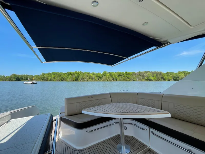 Slide: The Image of 2020 Sea Ray Sundancer 320 Coupe with shaded seating area on a serene lake. - 17