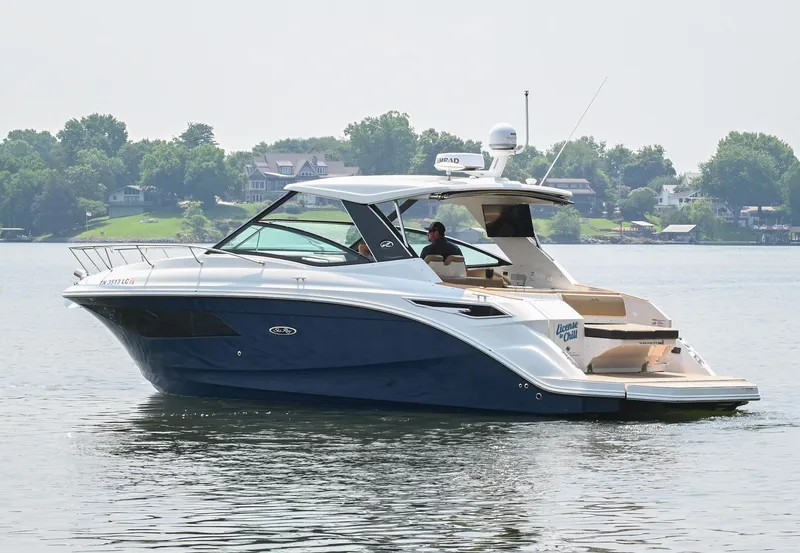 Slide: The Image of 2020 Sea Ray Sundancer 320 Coupe cruising on a calm lake with scenic background. - 2