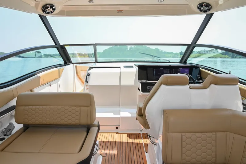 Slide: The Image of 2020 Sea Ray Sundancer 320 Coupe interior with tan seating and modern dashboard. - 26