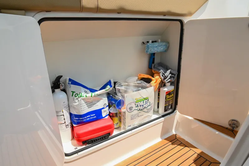 Slide: The Image of Storage compartment on 2020 Sea Ray Sundancer 320 Coupe with cleaning supplies and essentials. - 37