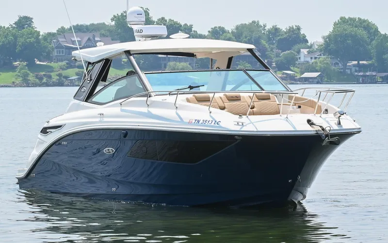 Slide: The Image of 2020 Sea Ray Sundancer 320 Coupe on calm water, showcasing sleek design and luxury features. - 6