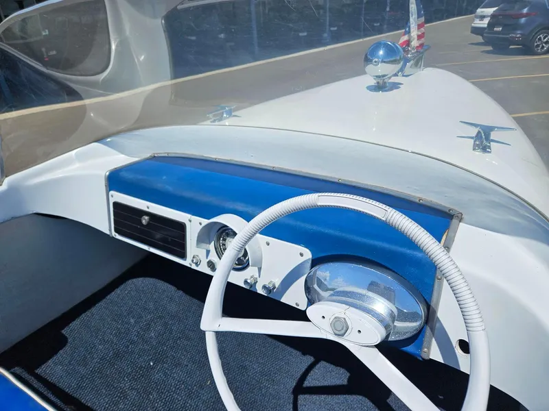 Slide: The Image of 1958 Larson Falls Flyer boat dashboard with vintage steering wheel and blue accents. - 4