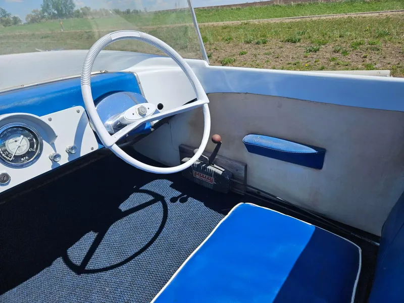 Slide: The Image of 1958 Larson Falls Flyer boat interior with blue and white seating and steering wheel. - 7