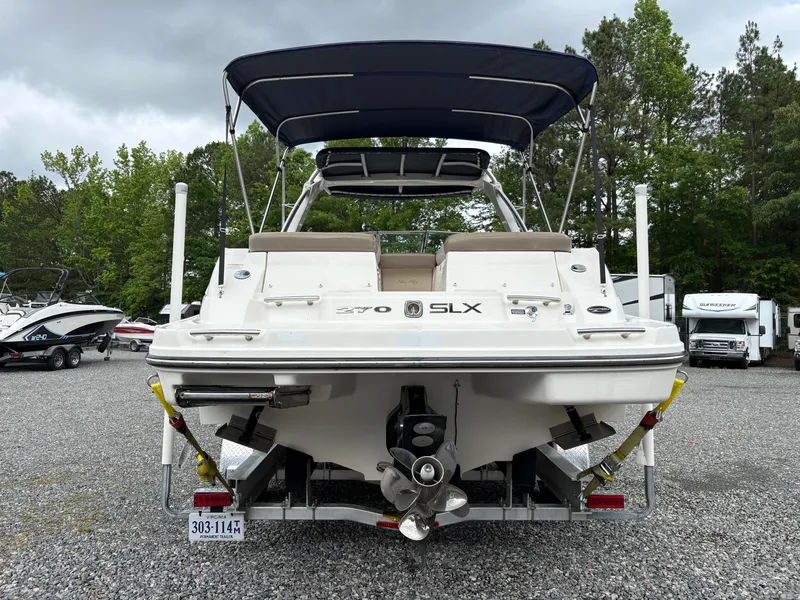 Slide: The Image of 2011 Sea Ray 270 SLX boat with canopy, parked on gravel lot. - 3