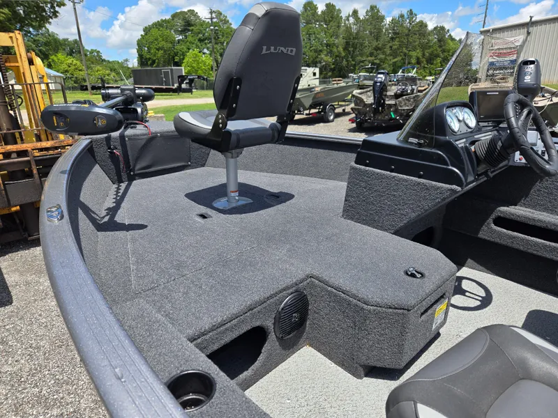 Slide: The Image of 2022 Lund 1775 Adventure SS boat interior with seating and control panel, under a clear blue sky. - 11