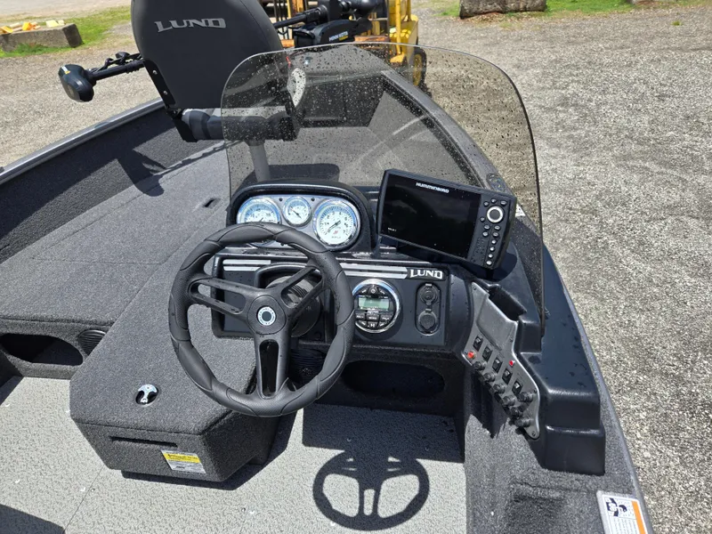 Slide: The Image of 2022 Lund 1775 Adventure SS boat dashboard with steering wheel and navigation system. - 13