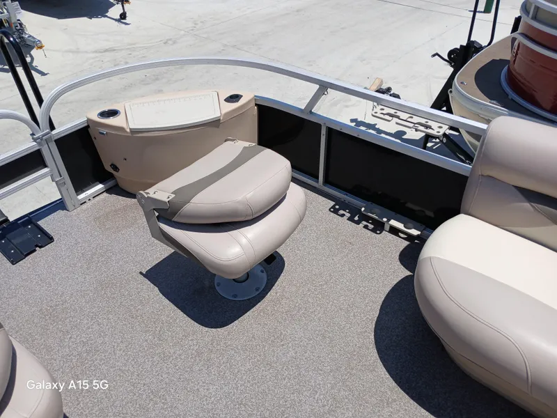 Slide: The Image of 2015 Sun Tracker Fishin Barge 24 DLX interior with beige seating and fishing chair. - 13