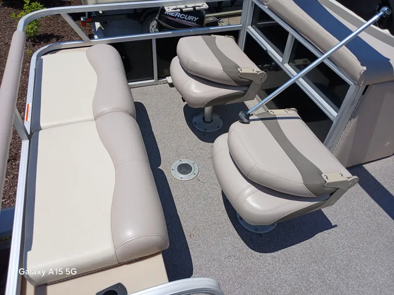 Slide: The Image of 2015 Sun Tracker Fishin Barge 24 DLX interior with beige seating and fishing chairs. - 5