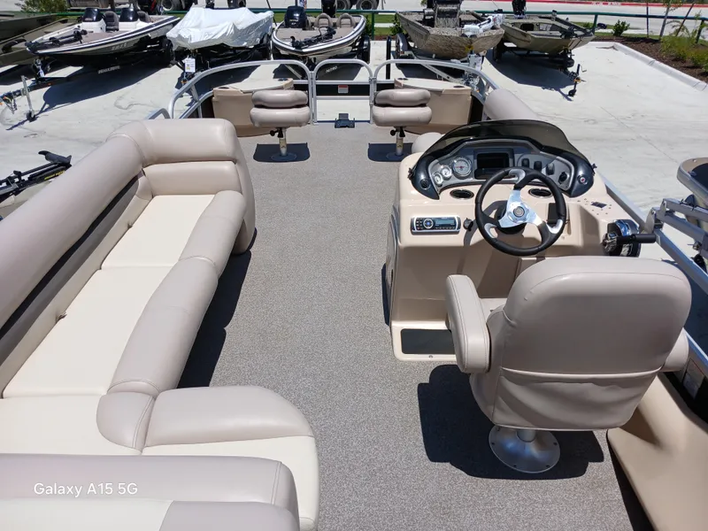 Slide: The Image of 2015 Sun Tracker Fishin Barge 24 DLX interior with beige seating and steering console. - 6