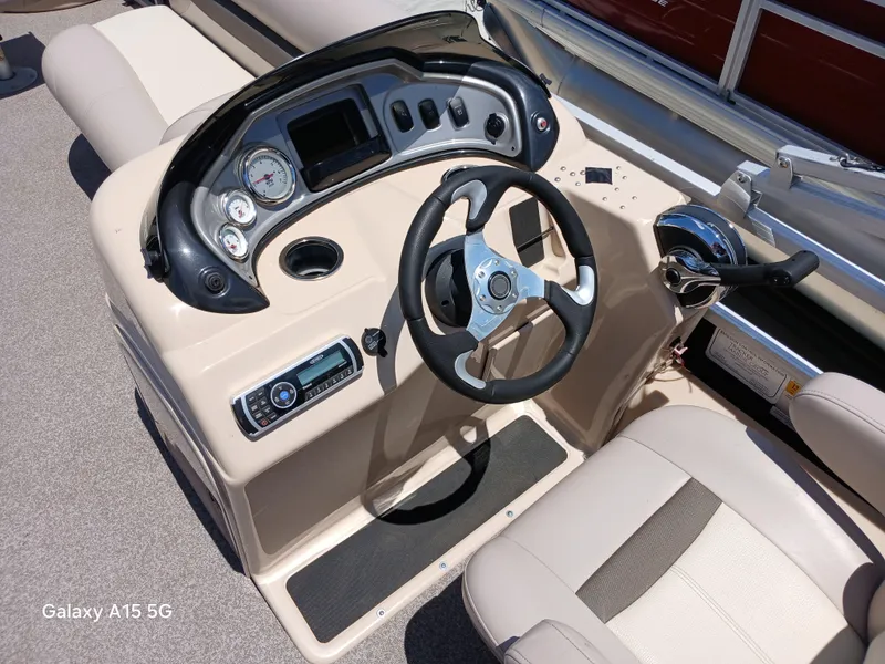 Slide: The Image of 2015 Sun Tracker Fishin Barge 24 DLX dashboard with steering wheel and controls. - 9