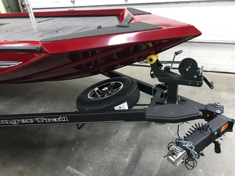 Slide: The Image of 2025 Ranger RT178C boat on trailer, red hull, black trailer, garage setting. - 11