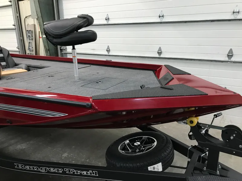 Slide: The Image of 2025 Ranger RT178C boat in a garage, featuring a sleek red design and elevated seat. - 2