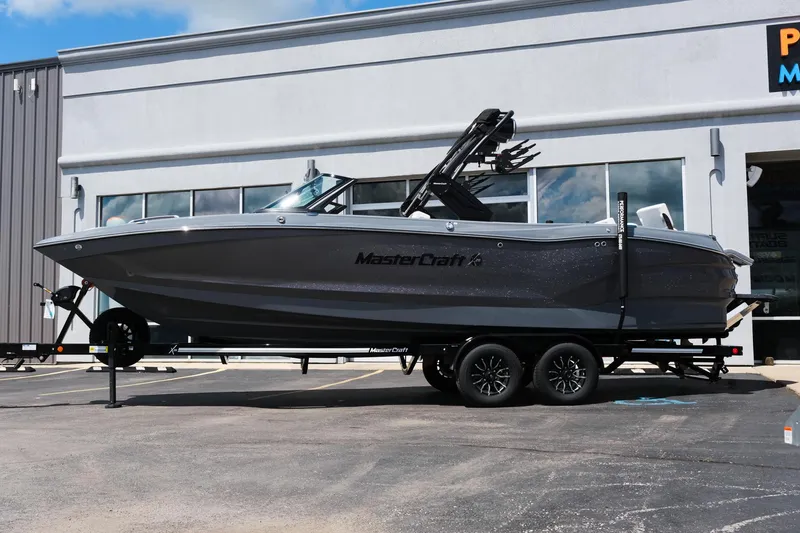 Slide: The Image of 2025 MasterCraft X26 boat on trailer outside dealership. - 3