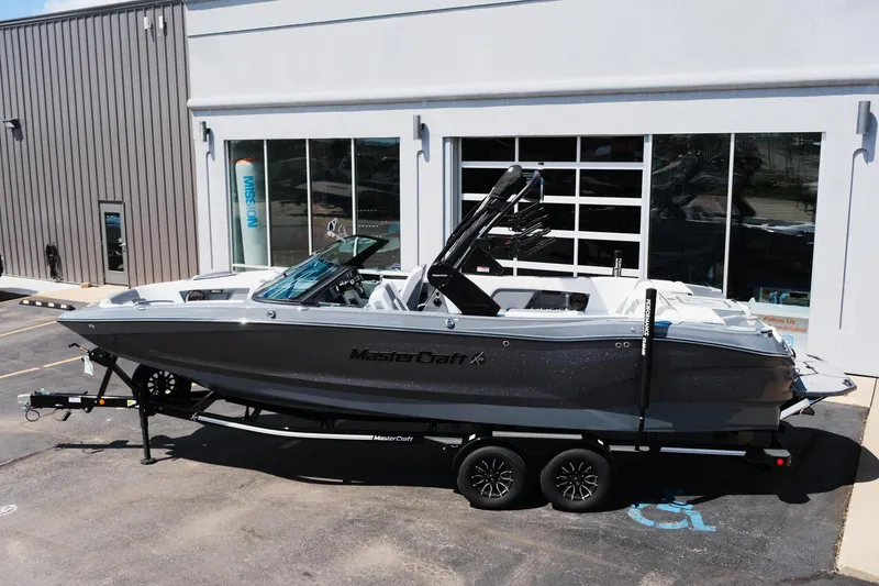 Slide: The Image of 2025 MasterCraft X26 boat on trailer outside dealership. - 45