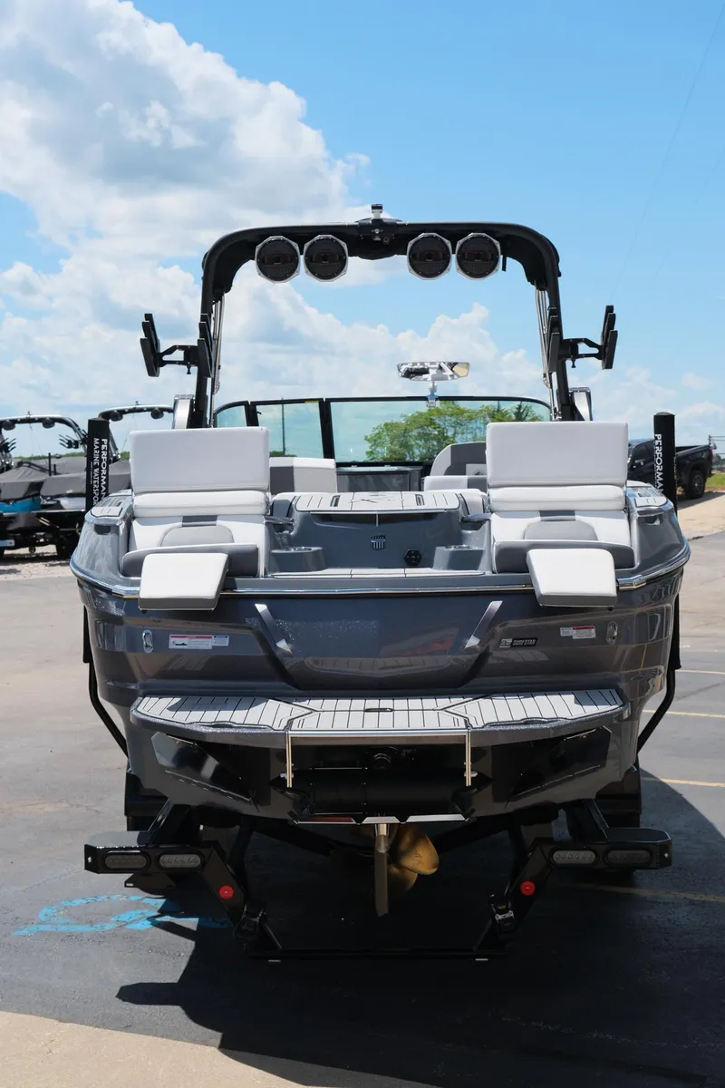 Slide: The Image of 2025 MasterCraft X26 boat, rear view, featuring sleek design and modern seating under a clear blue sky. - 6