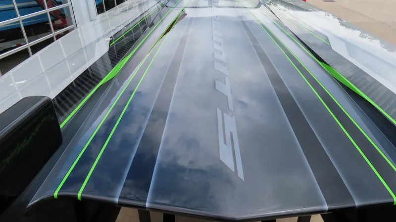 Slide: The Image of 2025 Outerlimits 46 SC boat with sleek design and green accents. - 13