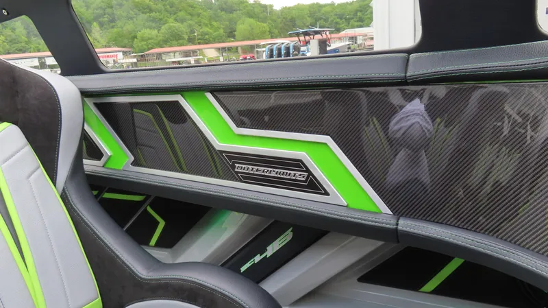 Slide: The Image of Interior of 2025 Outerlimits 46 SC boat with sleek carbon fiber and green accents. - 18