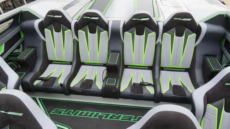 Slide: The Image of 2025 Outerlimits 46 SC boat interior with sleek, modern seating in black and neon green accents. - 21