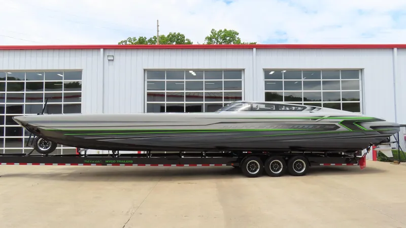 Slide: The Image of 2025 Outerlimits 46 SC powerboat on trailer, parked outside a garage. - 3