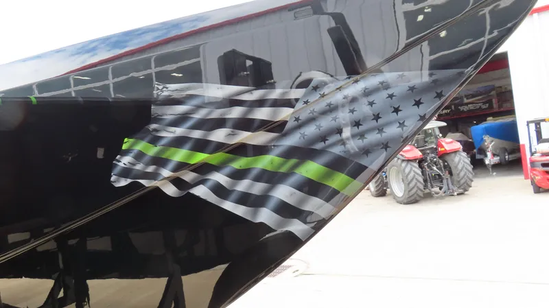 Slide: The Image of 2025 Outerlimits 46 SC boat with black and green flag design on the hull. - 7