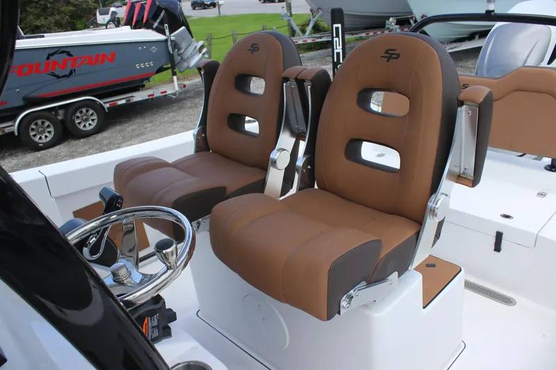 Slide: The Image of 2025 Sea Pro 245 FLX boat seats with brown upholstery and steering wheel. - 10