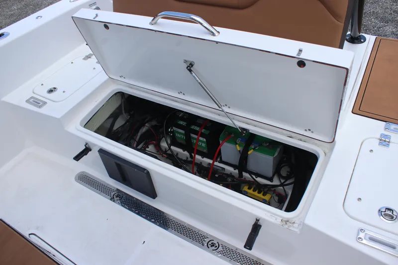 Slide: The Image of 2025 Sea Pro 245 FLX boat battery compartment with open hatch, showing wiring and components. - 12