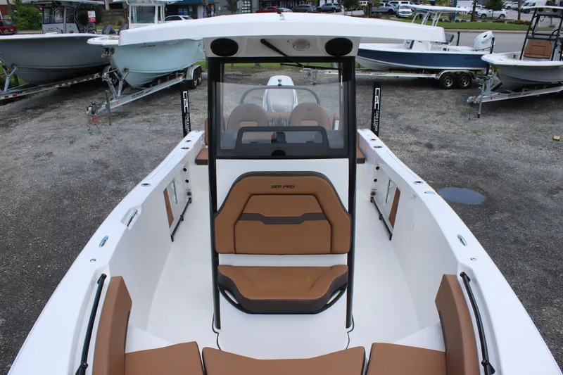 Slide: The Image of 2025 Sea Pro 245 FLX boat with tan seating, docked among other boats. - 16